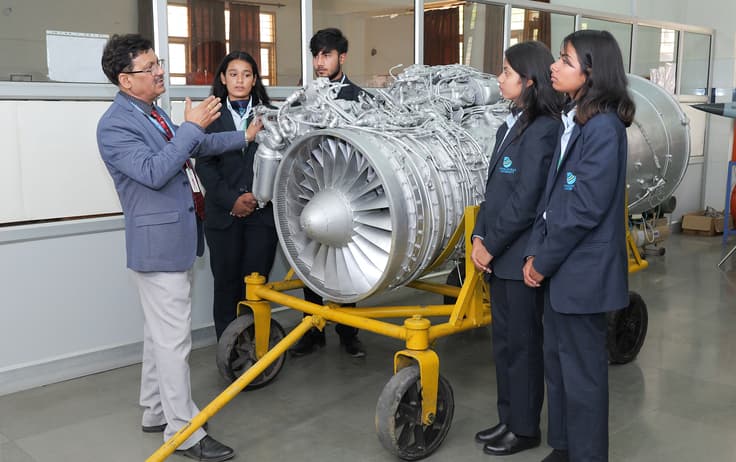 Aerospace faculty explaining jet engine components to students at Uttaranchal University propulsion lab